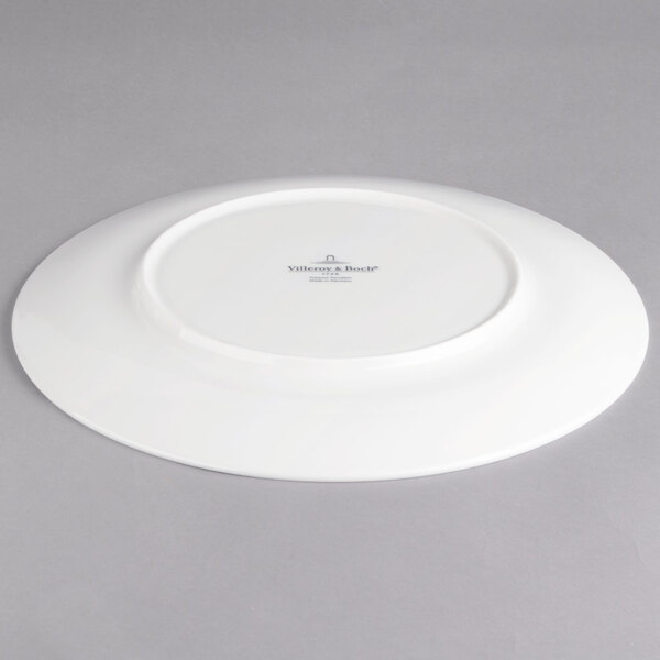 A white Villeroy & Boch porcelain flat plate with a small circular design in the center.