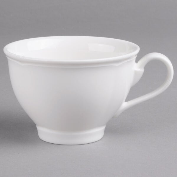 A close-up of a Villeroy & Boch white porcelain cup with a handle.