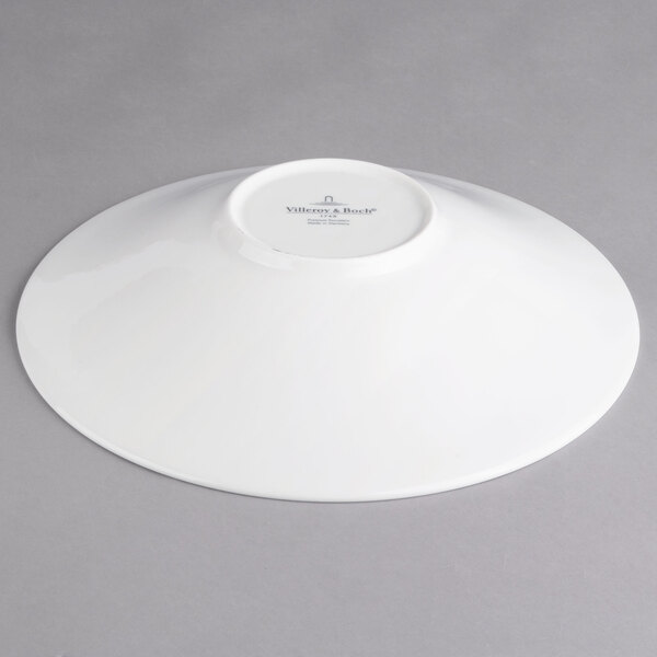 A Villeroy & Boch white porcelain coupe deep plate on a gray surface.