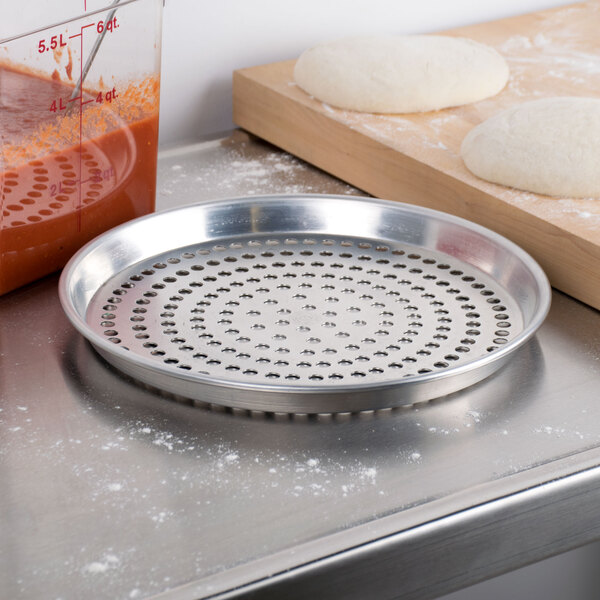 An American Metalcraft aluminum deep dish pizza pan with holes in it.