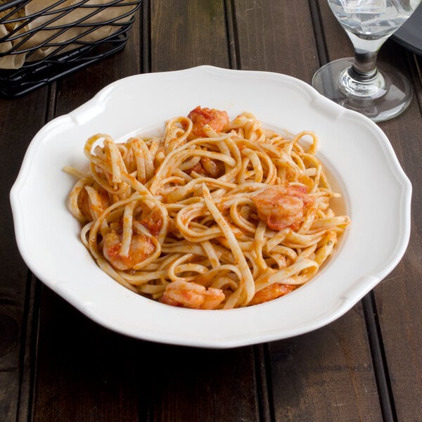 A Villeroy & Boch white porcelain soup plate with pasta and shrimp on it.