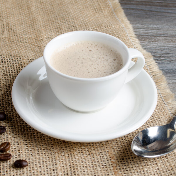 A Villeroy & Boch white porcelain cup of coffee on a saucer with a spoon.