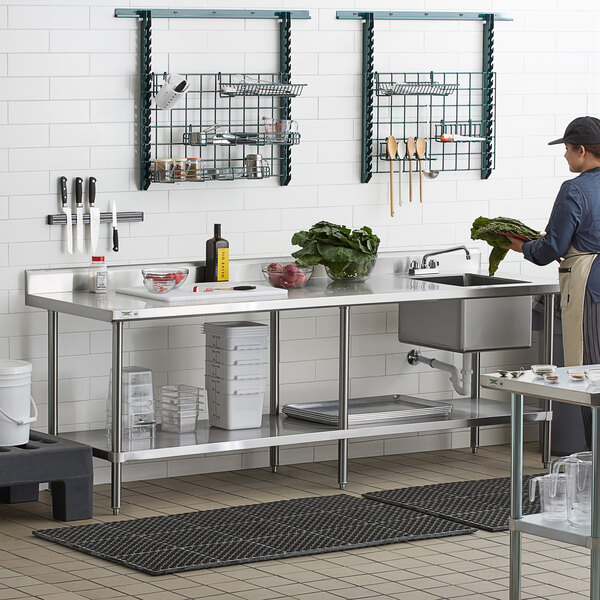 A stainless steel work table with an integrated sink and faucet, featuring the sink on the right side.