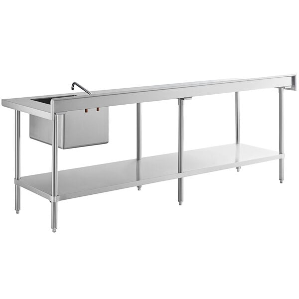 A long stainless steel work table with an integrated sink and faucet on the right side and a lower storage shelf.