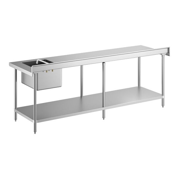 A long stainless steel work table with an integrated sink and faucet on the left side, supported by metal legs and featuring a lower shelf for storage.