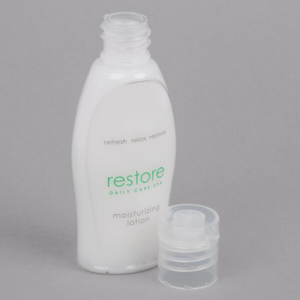 A close up of a white Dial Restore hand and body lotion bottle with a green cap and label.