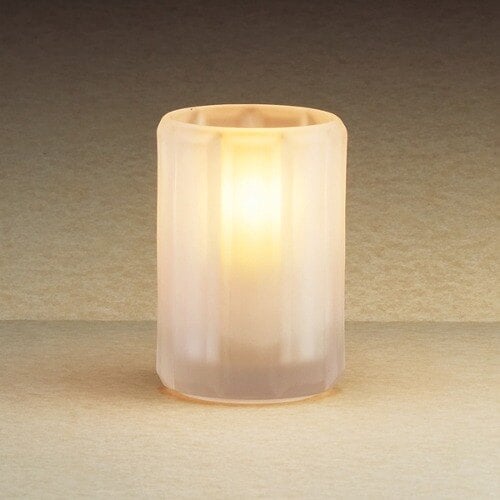 A lit Sterno Paragon frosted fluted candle holder on a table.