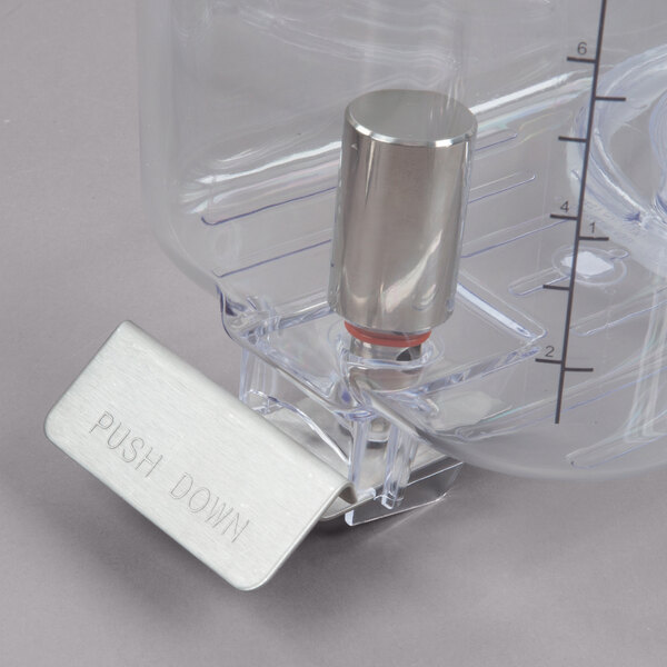 A close-up of a clear plastic bowl with a metal cylinder inside.