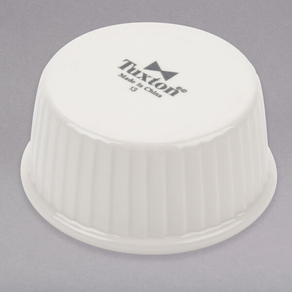 A white Tuxton china ramekin with black text on the side.