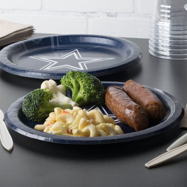 A Dallas Cowboys paper dinner plate with food on a table.