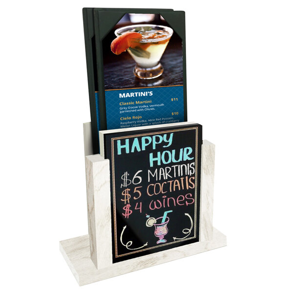 A white wash wood menu holder with a wet erase board insert holding a menu on a counter in a cocktail bar.
