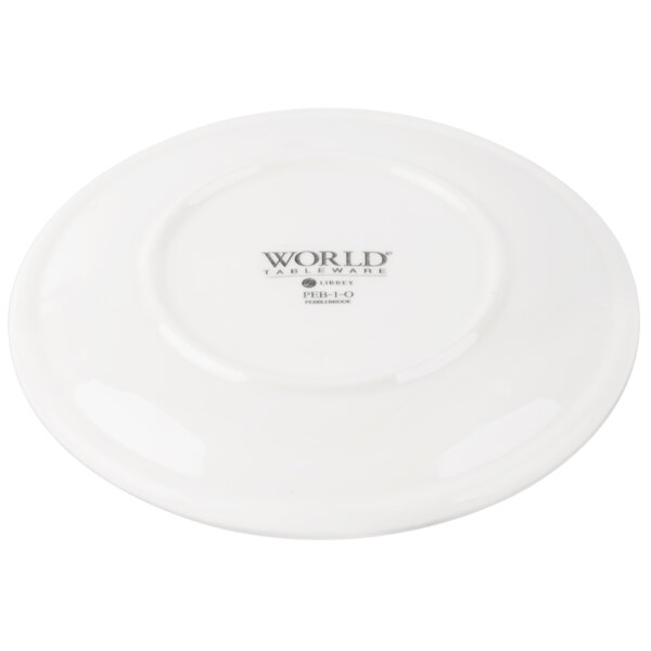 A white porcelain coupe plate with a textured black pebble design.