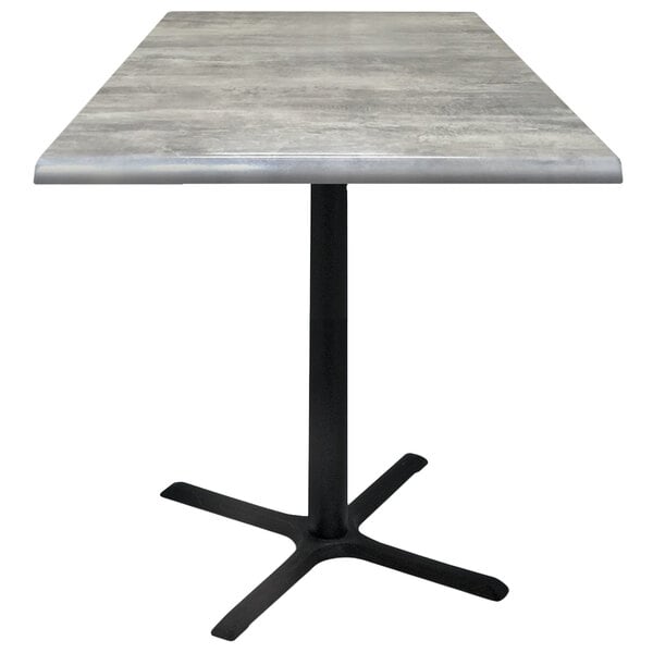A Holland Bar Stool 36" square greystone table with a black cross base.