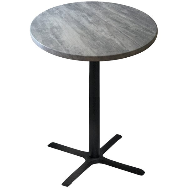 A round Holland Bar Stool outdoor counter height table with a grey stone top and metal base.