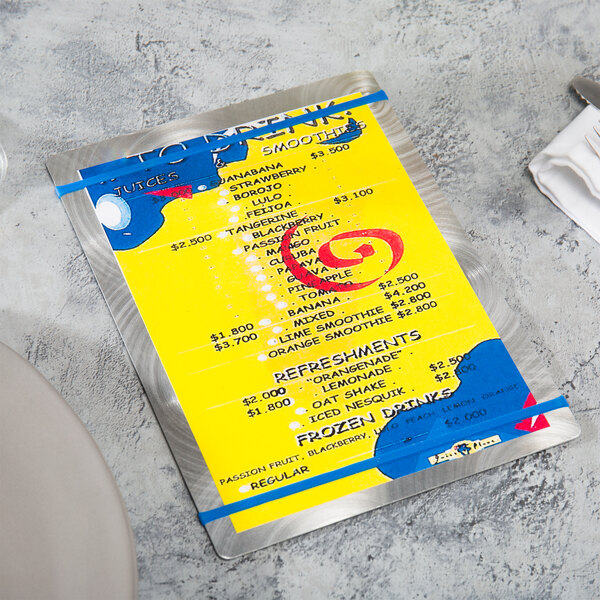 A Menu Solutions Alumitique menu board with royal blue bands on a yellow table.