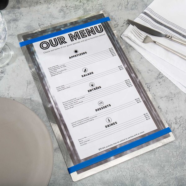 A Menu Solutions Alumitique menu board with Royal Blue bands on a table with silverware on a napkin.