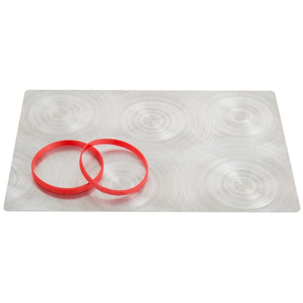 A white surface with a silver Alumitique menu board and red rubber bands.