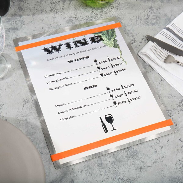 An Alumitique aluminum menu board with orange bands on a table with a menu.