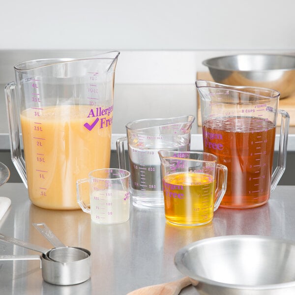 A purple Cambro measuring cup with brown liquid in it.