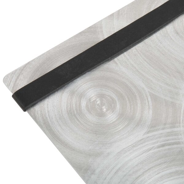 A Menu Solutions Alumitique aluminum menu board with black bands on a metal surface.