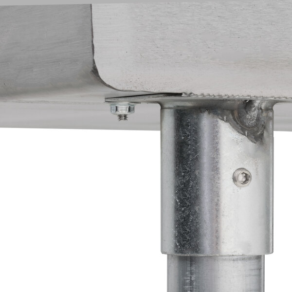 An Advance Tabco stainless steel commercial sink with metal pipes attached.