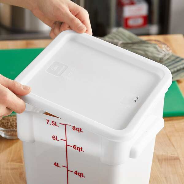A person's hands opening a white Choice polypropylene food storage container lid.
