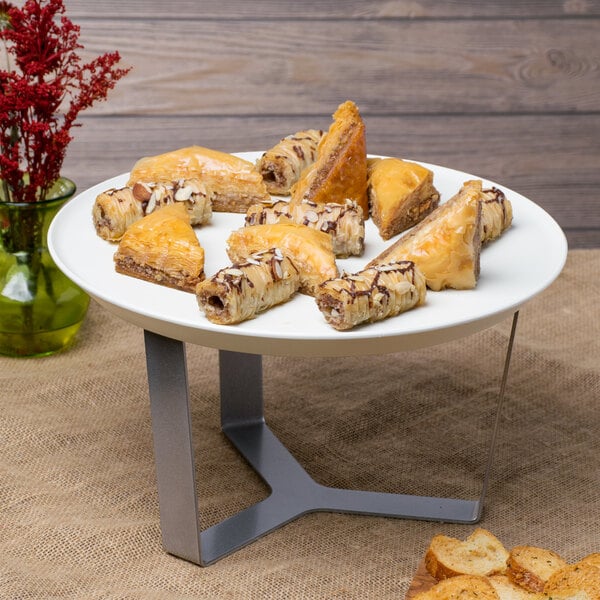 A white round tray with pastries on a table.