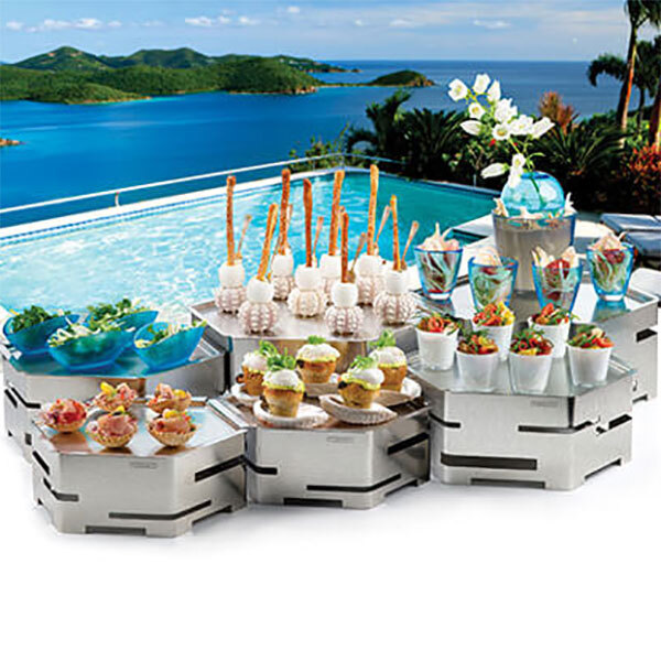 A table of food on a Rosseto stainless steel tray near the ocean.