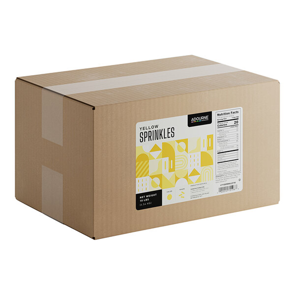 A large cardboard box labeled as containing 10 pounds of Adourne yellow sprinkles.