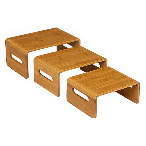 A set of natural bamboo nesting risers on a wooden table.