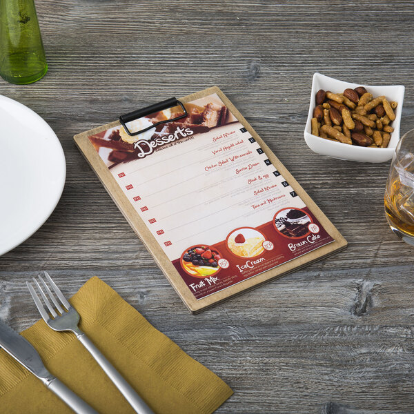 A weathered walnut wood menu clipboard on a table with a menu.