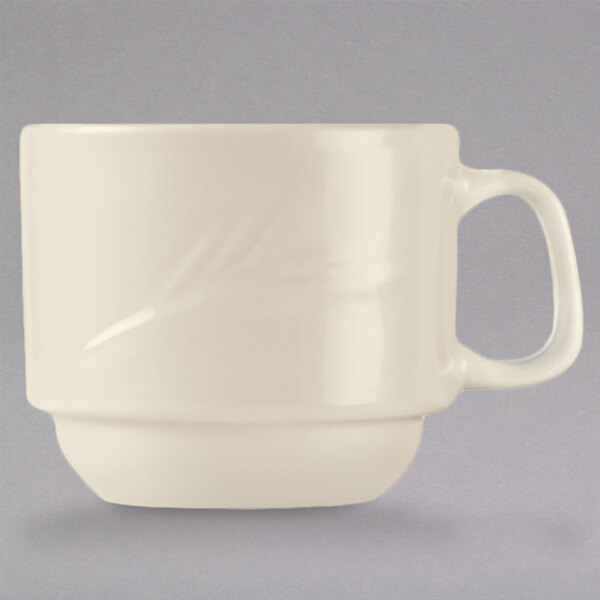 A close up of a Libbey cream white china cup with a handle.