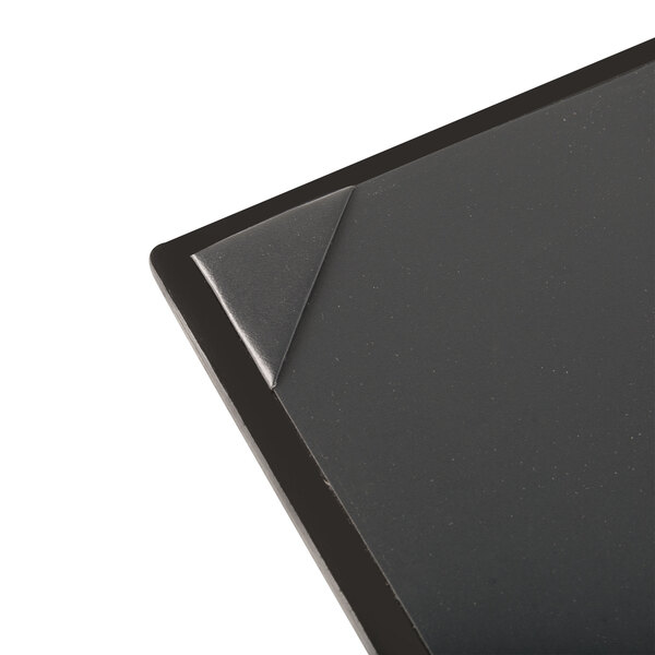 The corner of a black Menu Solutions wood board with a picture on it.