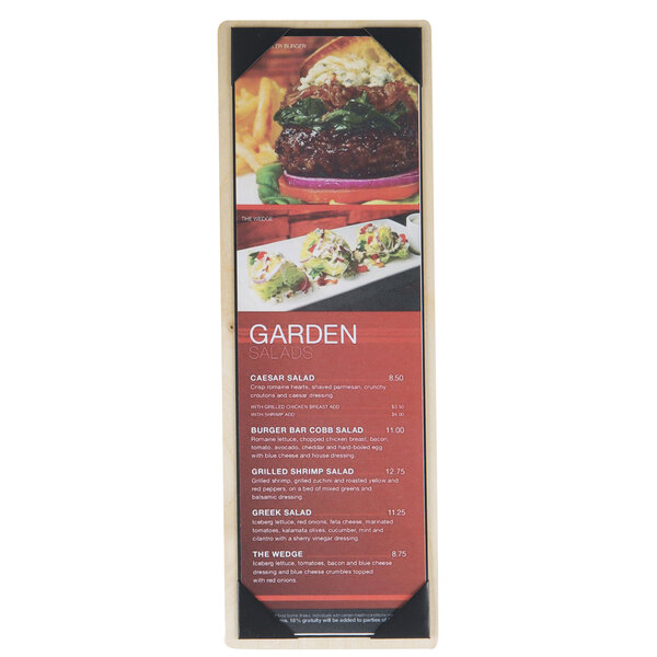 A Menu Solutions wood menu board with picture corners on a table with a plate of food.