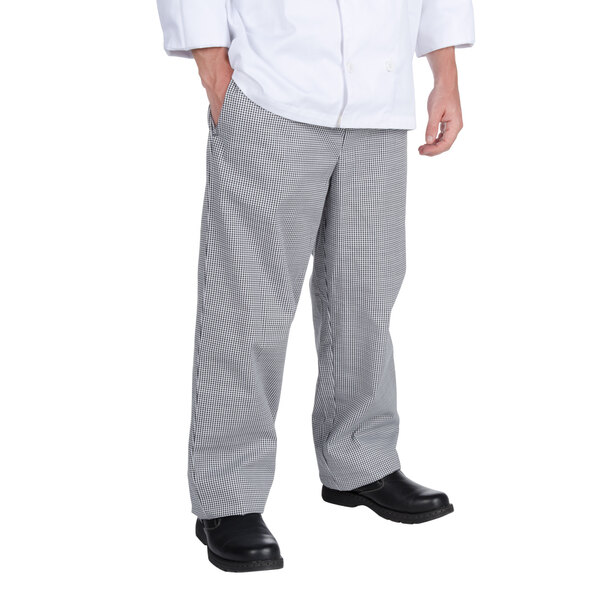 A person wearing Chef Revival Houndstooth baggy cook pants with their hands in their pockets.