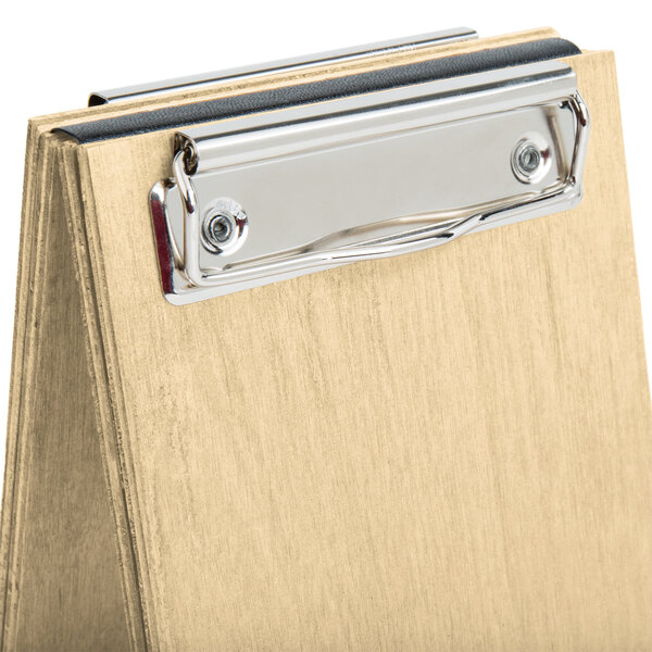 A natural wood Menu Solutions sandwich menu board tent with a metal clip.