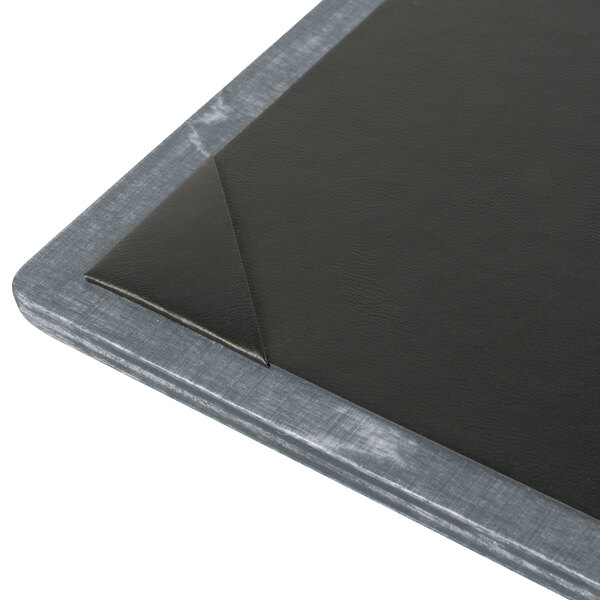 A customizable ash wood menu board with picture corners on a table in a bar.