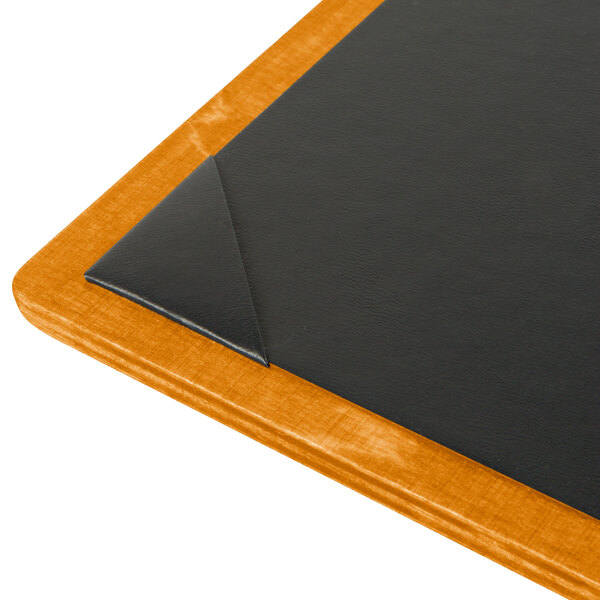A Menu Solutions Country Oak wood menu board with picture corners on a table in a bar.