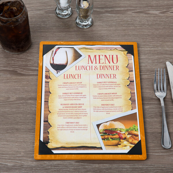 A Menu Solutions customizable wood menu board on a table with a picture of food inside.