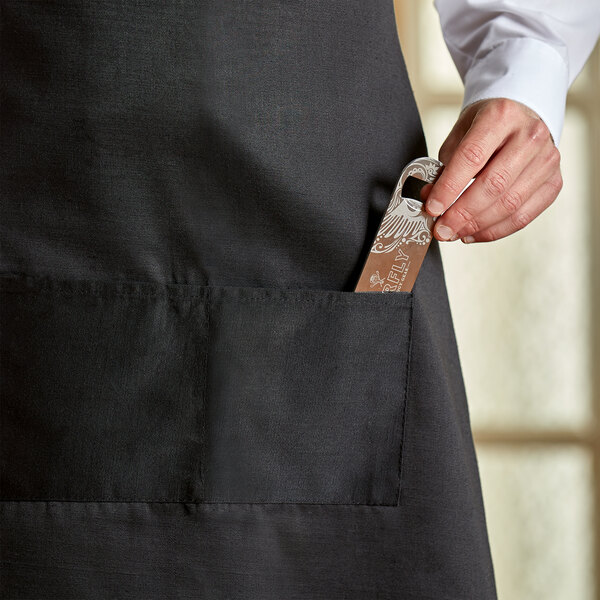 A person holding a knife in the apron pocket of a Choice Men's Server Tuxedo Set.