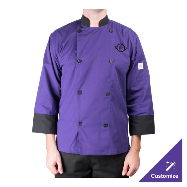 A person wearing a Mercer Culinary purple chef coat on a professional kitchen counter.