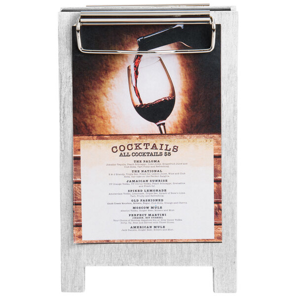 A Menu Solutions white wash wood sandwich menu board tent with clip on a wood table displaying a menu.