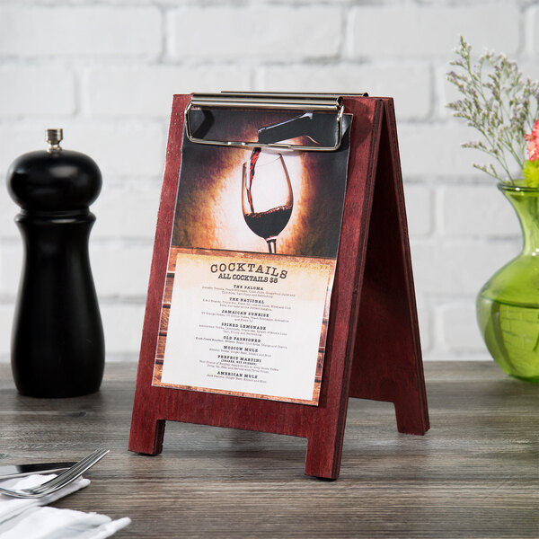 A Mahogany wood menu board tent with a menu on a table.
