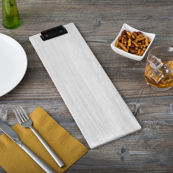 A wooden Menu Solutions wood clip board with a fork and knife on it.