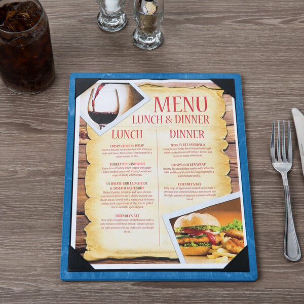 A blue wood menu board with picture corners holding a lunch and dinner menu.