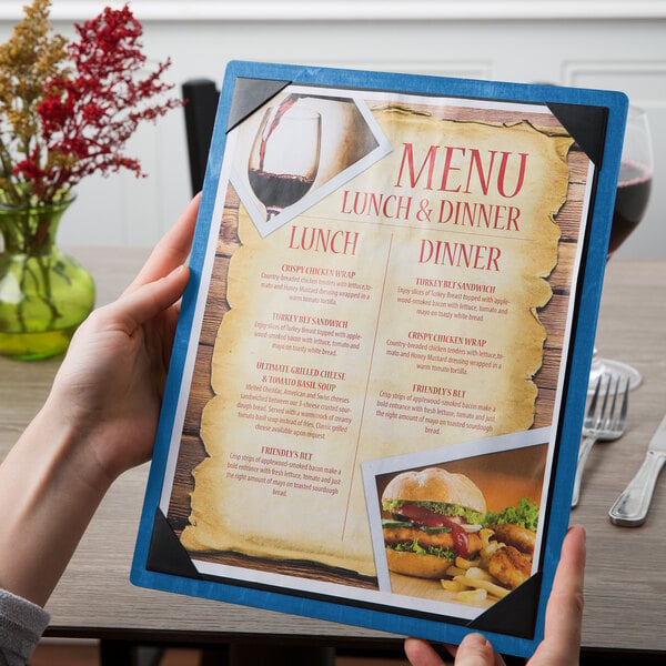 A blue wood menu board with picture corners holding a lunch and dinner menu.