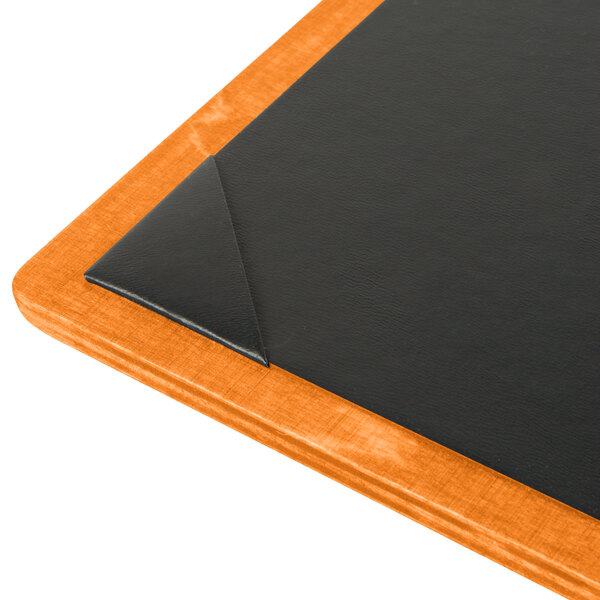 A black wood Menu Solutions board with picture corners on a table.