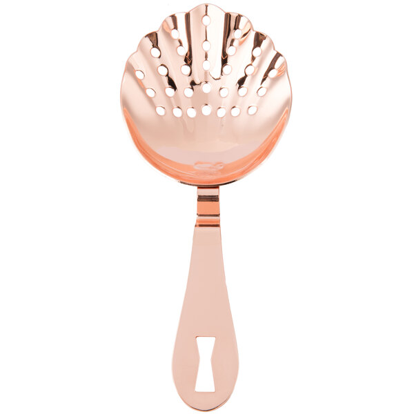 A close-up of a copper-plated scalloped spoon with holes.