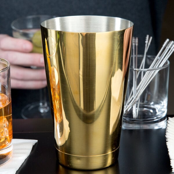 A close-up of a gold-plated Barfly cocktail shaker tin.