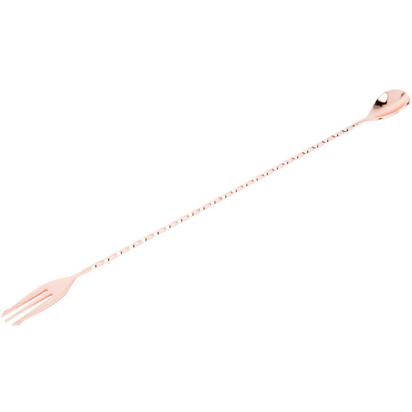 A long metal bar spoon with a fork end and a copper plating.
